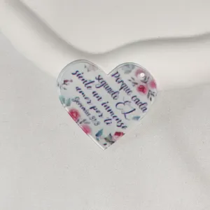 Acrylic heart charm detail showcasing floral print and inspirational Spanish scripture text.