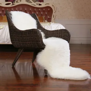 Vue détaillée du tapis en fausse fourrure blanche drapé sur une chaise de chambre.