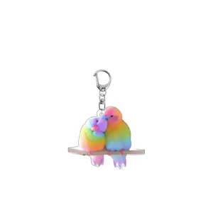 Close-up detail of the colorful parrot acrylic keychain, showing vibrant rainbow bird print design.