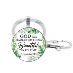 Gedetailleerde close-up van de metalen sleutelhanger met helder glas en inspirerende quote.