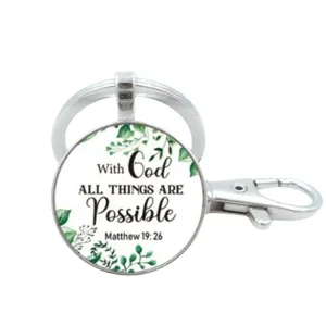 Inspirerende christelijke metalen sleutelhanger met glazen cabochon en groene bladeren.