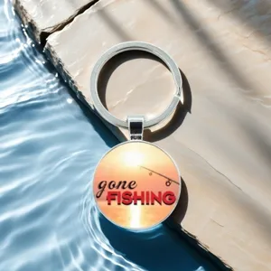 Detailed view of fishing theme glass cabochon keychain, sunset bait design with metal ring.