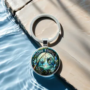 Fishing theme metal keychain with round glass dome and rod graphic charm for outdoor sports fans.