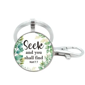 Close-up van inspirerende bijbel citaat glas cabochon sleutelhanger met zilveren metalen ring.