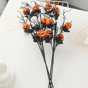 Halloween black branch bouquet with scary orange pumpkin ornaments for home party decor.