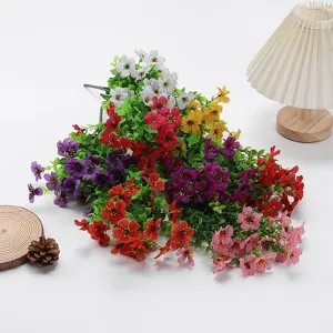 Close-up details of vibrant multi-colored artificial flower bunches with green eucalyptus leaves.