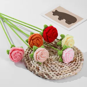 Handgefertigte Häkel-Rosenblüten Detailansicht, zeigt feine Wollstricktextur und Stängel.