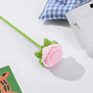 Nahaufnahme Detail einer handgehäkelten rosa Rose mit grünem Stiel für die Raumdeko.