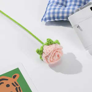 Handgehäkelte rosafarbene Rose im Detail, perfekte DIY-Heimdekoration für Blumensträuße.