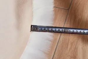Nahaufnahme der weissen Kunstfellteppich-Flauschigkeit und Randdicke, ideal fur gemütliches Zimmer.