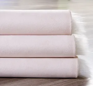 Close-up detail of soft pink plush rug with fluffy white edge, cozy home decor and cushion.