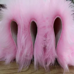 Detalle de tela de alfombra de pelo sintético rosa con textura suave y felpa larga.