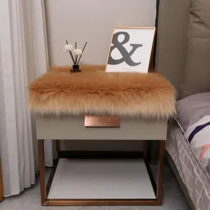Close up view of fluffy faux fur nightstand mat in cozy bedroom, soft plush texture display.