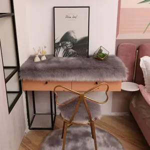 Grey faux fur desk mat, chair cushion and fluffy rug set for cozy home bedroom decor.