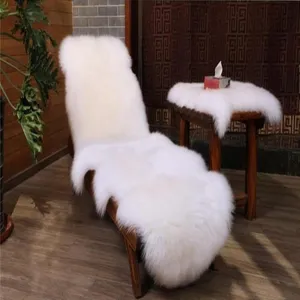 White genuine sheepskin rug cushion for sofa, fluffy fur mat detail view showing soft long hair.