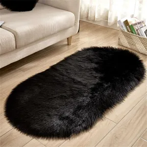 Faux sheepskin oval black fluffy rug detail shot, soft plush carpet for living room.