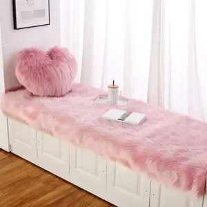 Accogliente cuscino in pelliccia sintetica rosa per finestra con cuscino a cuore.