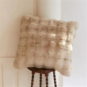 Detail shot of a cream faux fur plush cushion cover, showcasing soft fluffy texture.