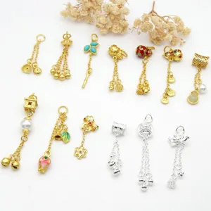 Detailed view of assorted antique gold and silver DIY charms, tassels, and pearl pendants.