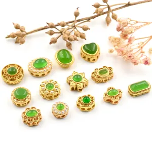 Close-up of assorted ancient gold style green jadeite gemstone jewelry spacer beads and DIY charms.