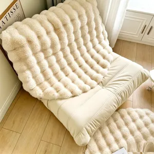 Cream plush lazy sofa cushion and round furry floor mat set for cozy living room decor.