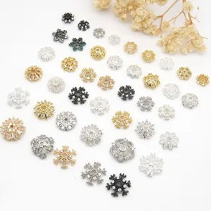 Detailansicht von verschiedenen Strass Blumen Perlenkappen und Abstandsperlen fuer Schmuck.