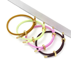 Vista dettagliata di bracciali in corda intrecciata regolabile con perline scorrevoli metalliche.