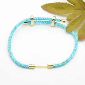 Light blue braided bracelet detail featuring gold metal components close up view style