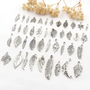 Gedetailleerd overzicht antieke zilveren blad veer vleugel hangers sieraden.