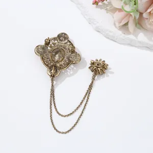 Vintage baroque double pin brooch detail view, antique bronze metal chain accessory.