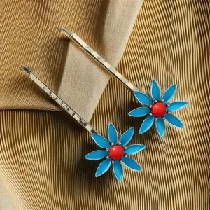 Gros plan de pinces à cheveux florales en émail de style chinois, accessoires en métal.