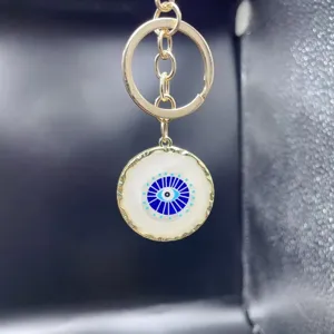 Alloy evil eye keychain, golden metal ring, stylish evil eye bag pendant and car key accessory.