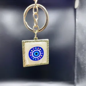 Metal evil eye keychain charm, golden square pendant handbag accessory and car key ring.