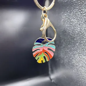 Colorful enamel monstera leaf metal keychain bag charm pendant with golden lobster clasp.