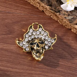 Vintage gold tone crystal rhinestone skull brooch detail close up showcasing sparkling gems.