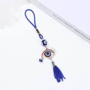 Vista dettagliata dell'ornamento sospeso con amuleto malocchio blu e strass scintillanti.