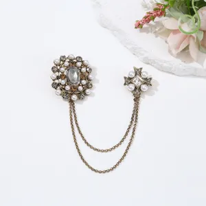 Vintage baroque brooch with pearls, crystals, and double chains for retro fashion outfits.