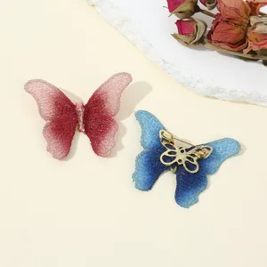 Detailed close-up view of delicate fabric embroidered butterfly brooches in gradients.