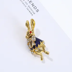 Exquisita broche de conejo chapada en oro con esmalte azul y diamantes de imitacion brillantes.