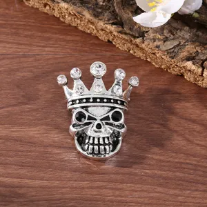 Vintage rhinestone skull brooch pin with crown design, gothic fashion metal jewelry for party.