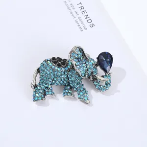Close-up detail of rhinestone elephant brooch showing sparkling blue crystals and metallic texture.