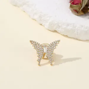 Close up detail of sparkling crystal butterfly brooch, elegant gold tone metal accessory.
