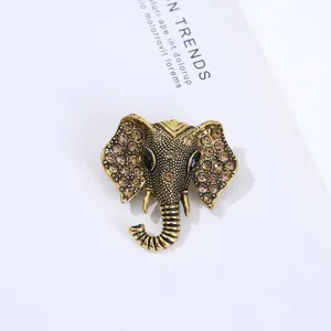 Vintage gold elephant brooch with sparkling brown rhinestones. Elegant animal lapel pin accessory.