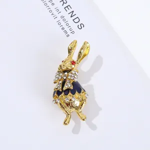 Elegante broche de conejo dorado con pedrería brillante y diseño de esmalte azul.