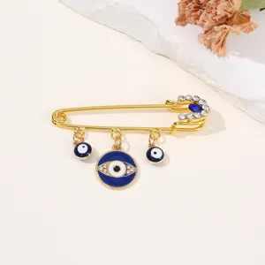 Gros plan détail de la broche épingle de sûreté œil grec doré avec des strass étincoyants et bleus.