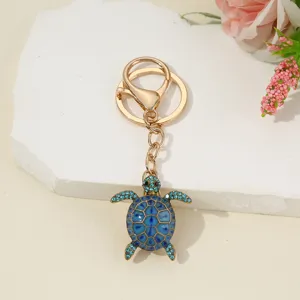 Detailed view of a cute blue rhinestone turtle keychain, alloy animal keyring pendant.