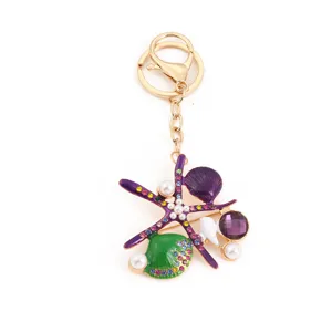 Gedetailleerd overzicht van de ocean stijl zeester sleutelhanger met paarse schelpen en strass.