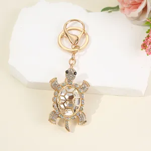 Detailed view of a gold-tone rhinestone crystal turtle keychain and stylish bag charm pendant.