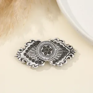 Dettaglio di fibbia doppia in strass argentato per pelliccia, elegante bottone decorativo.