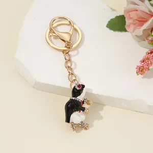 Close-up detail of the cute rhinestone penguin keychain with gold hardware and metal ring.